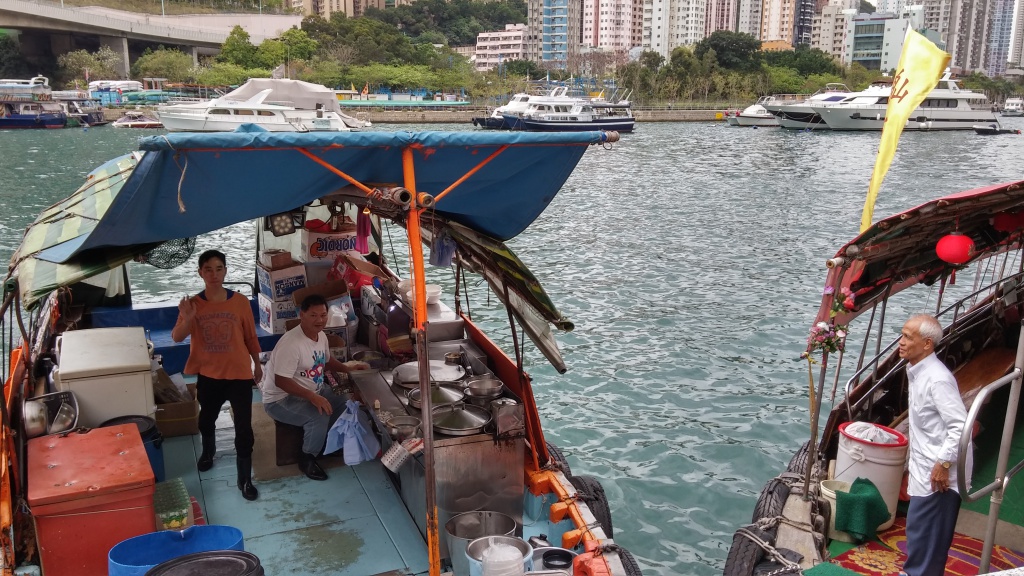 The sampan helmsman is buying lunch box from the sampan canteen at Aberdeen