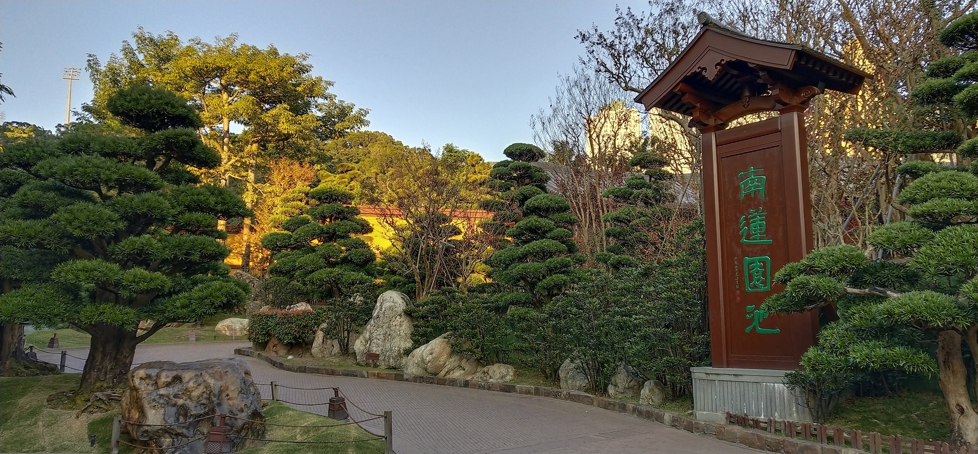 wooden plaque, path, trees, stones