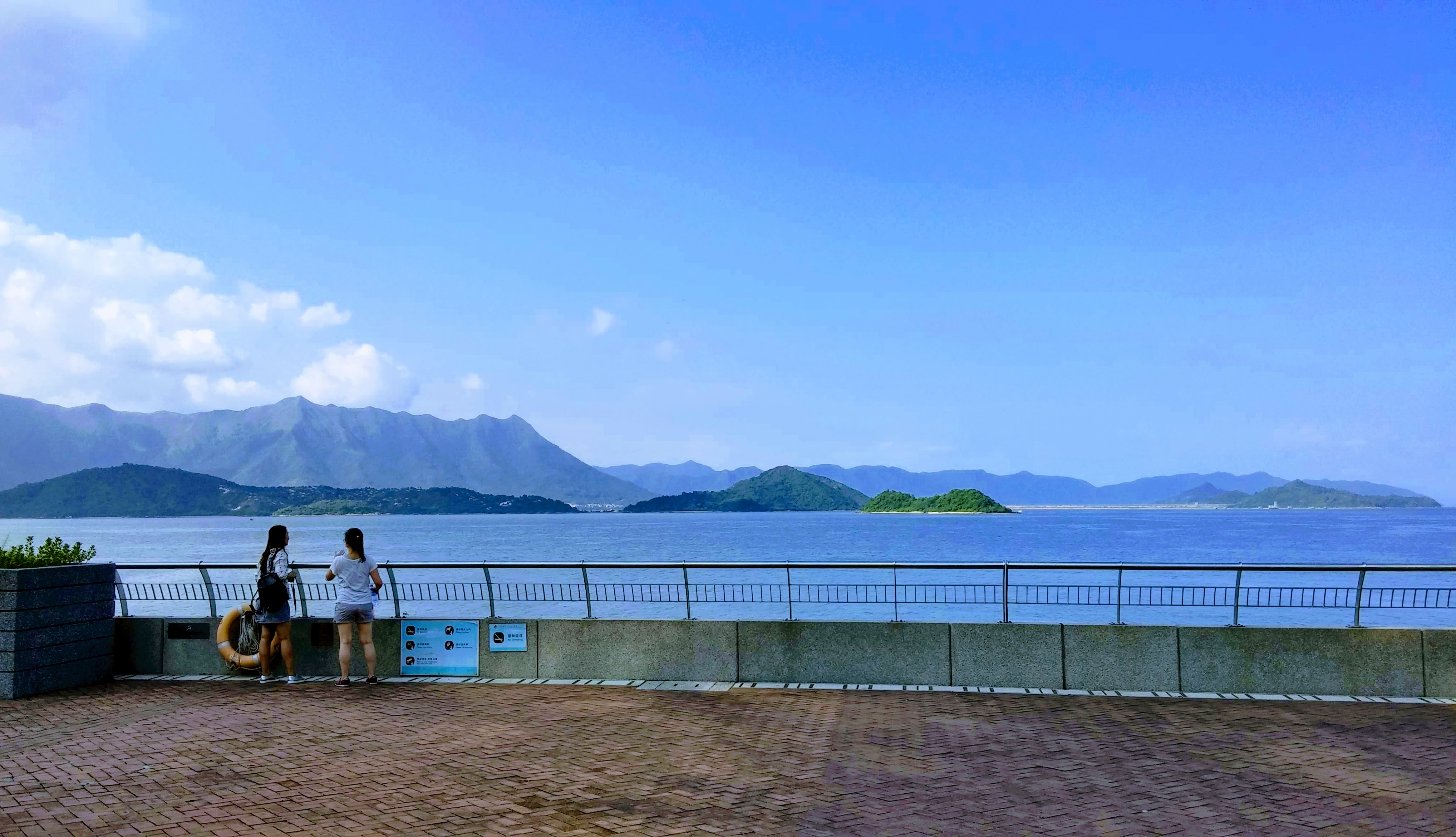 blue sky, green hill, sea, waterfront, girls