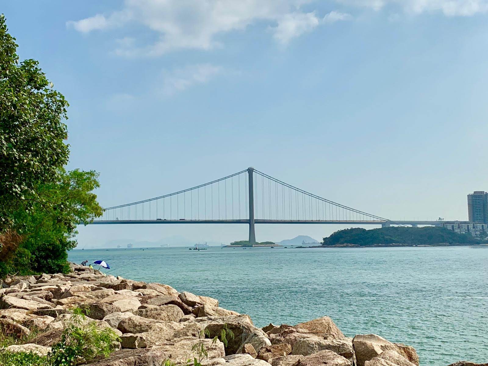 blue sky, long bridge, sea, rocky shore