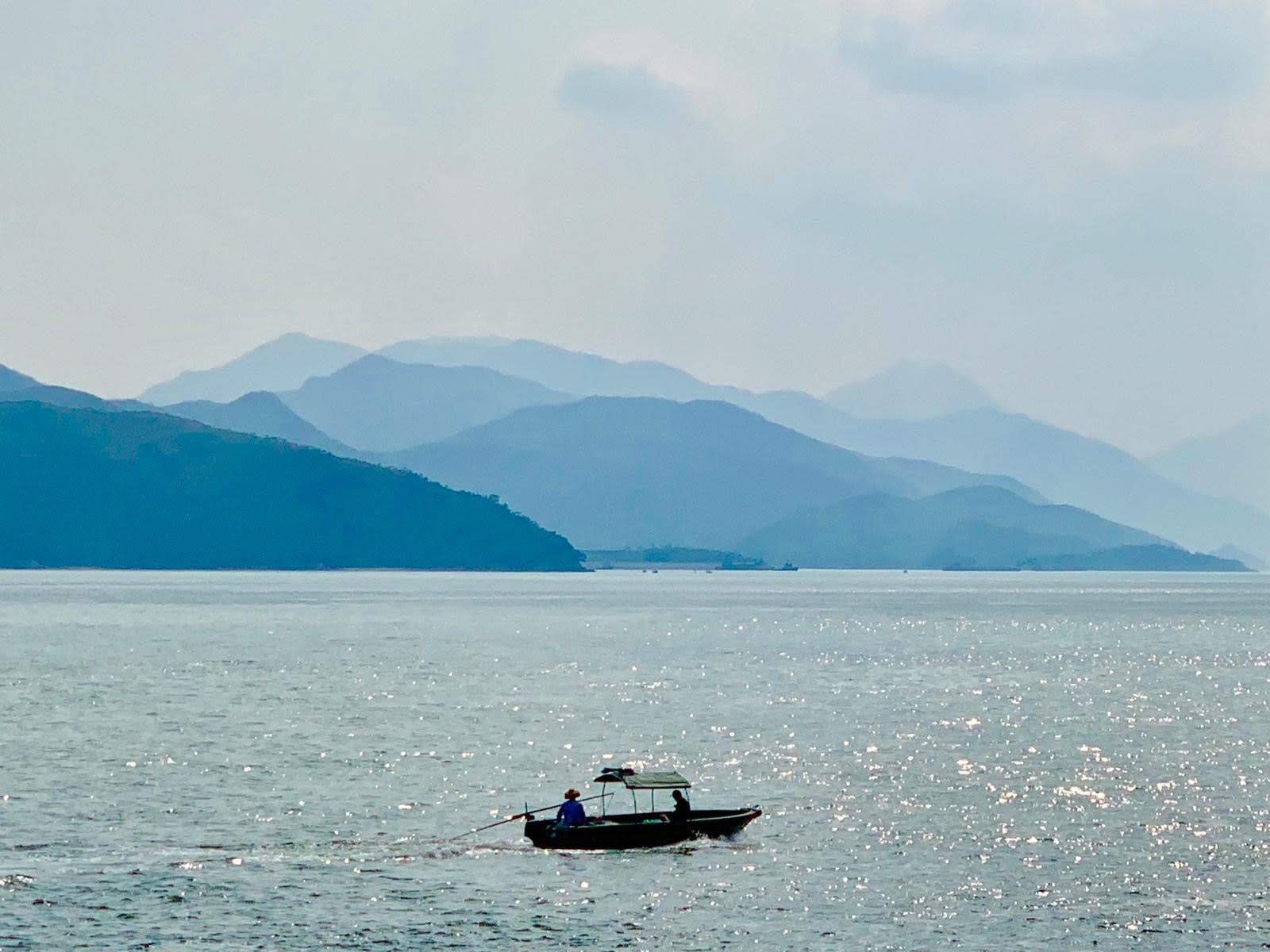 misty sky, hills, sea, boat, anglers