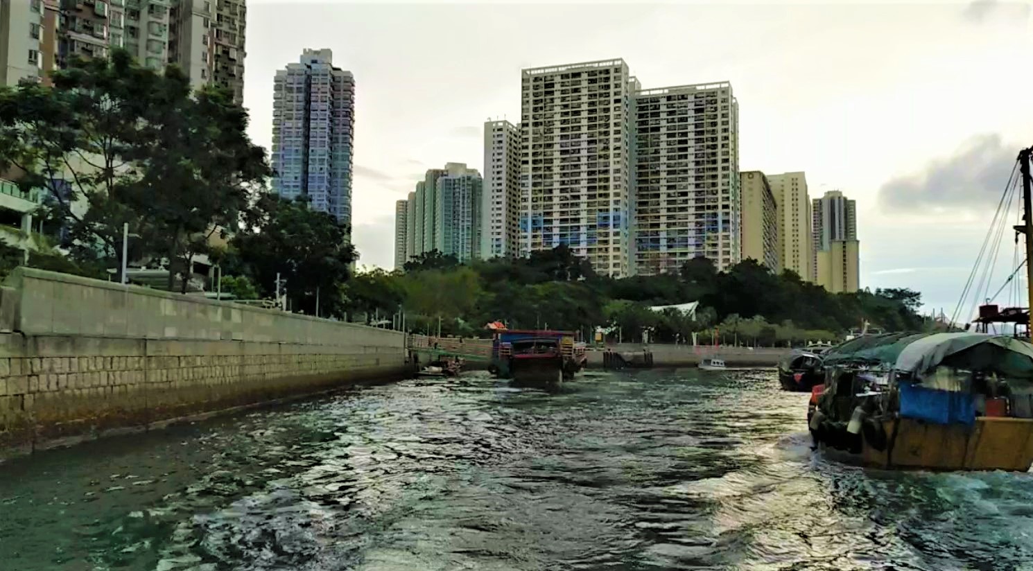 See tall buildings on Ap Lei Chau Island from sampan boat