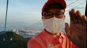 Selfie of Frank in Ngong Ping Cable Car cabin, Hong Kong Airport as the backdrop