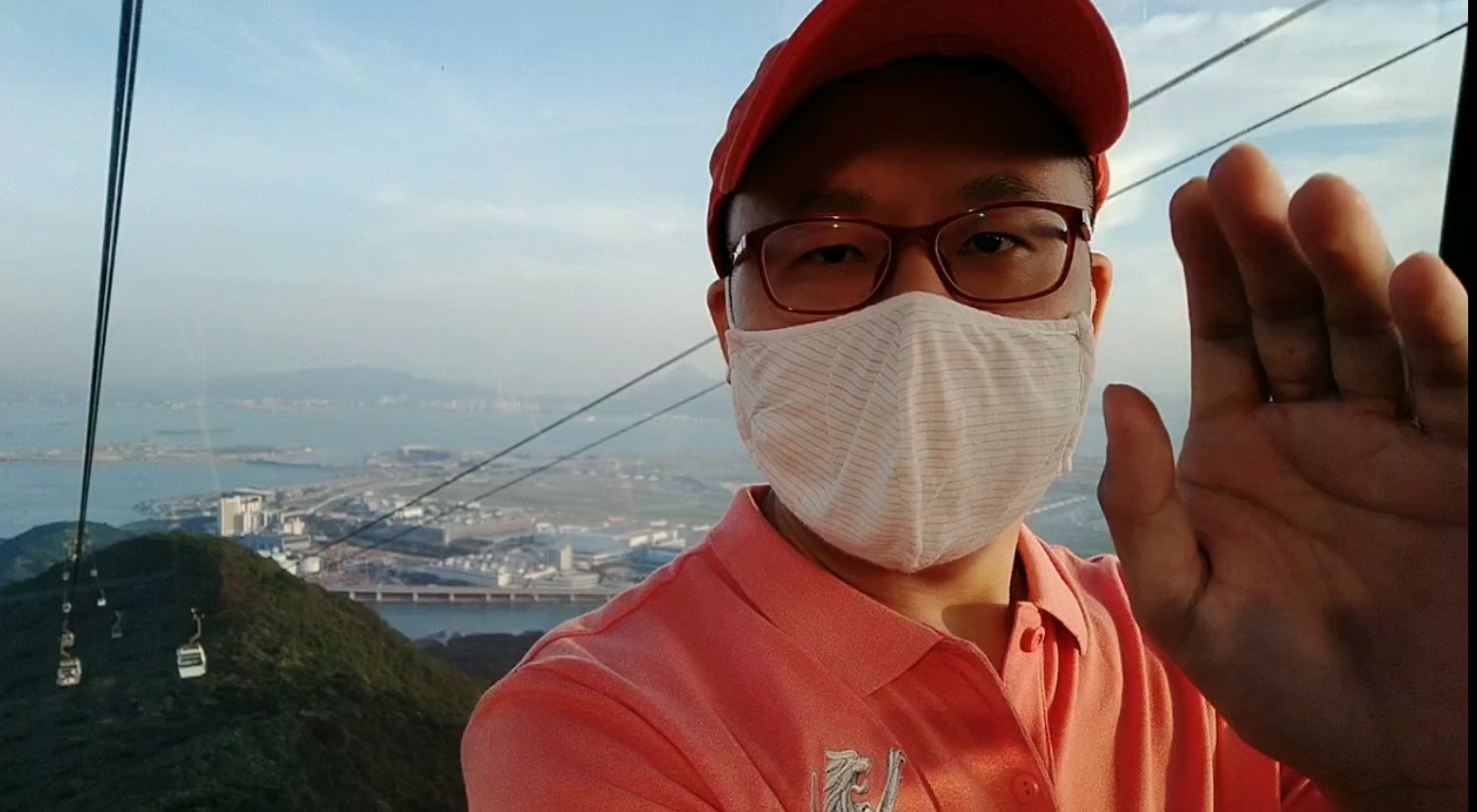 Selfie of Frank in Ngong Ping Cable Car cabin, Hong Kong Airport as the backdrop