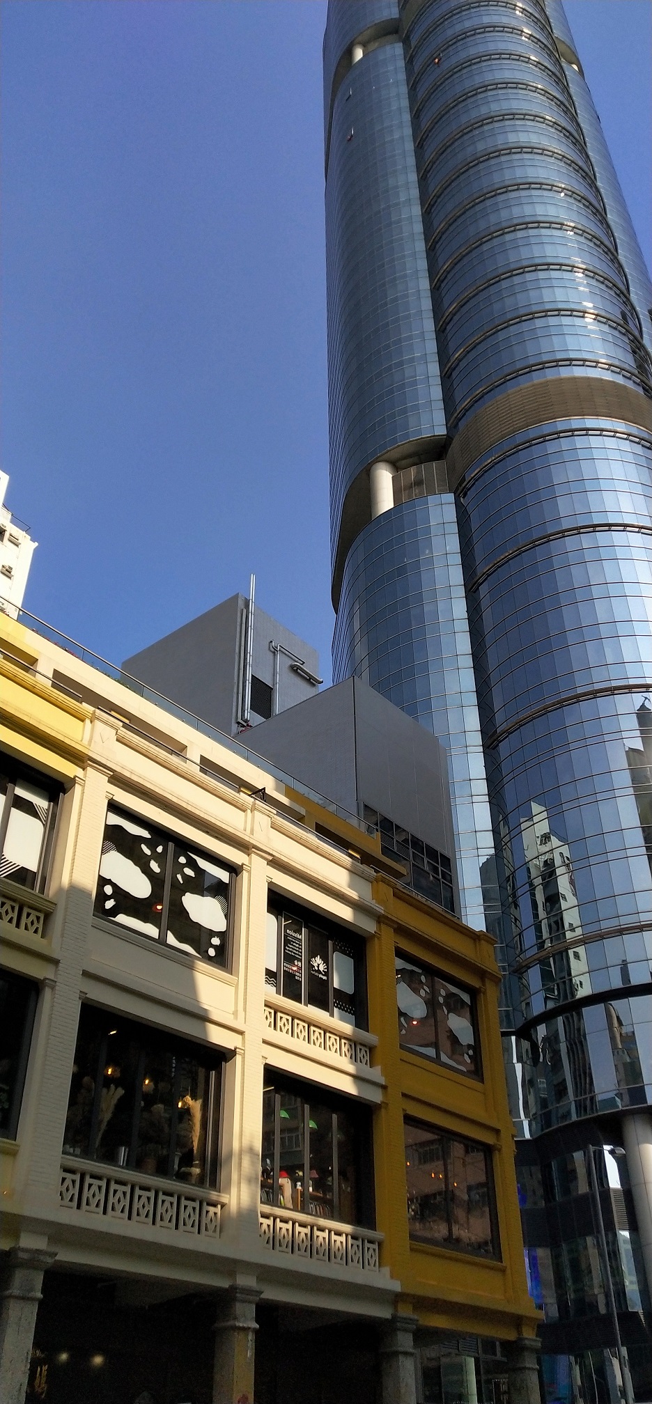 The restored Shanghai Street 618 is right next to the modern building, Langham Place Mall