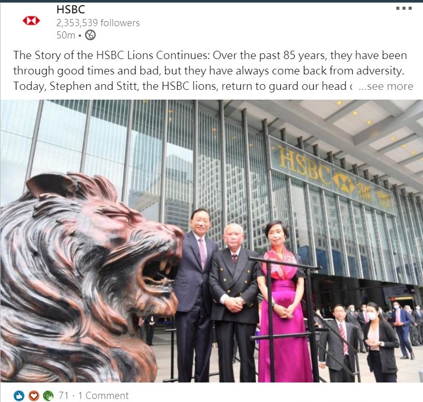 HSBC senior management staff and the fung shui master (in the middle) take photo next to the lion statue Stephen
