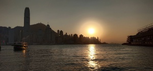 Star Ferry leaves Tsim Sha Tsui Pier duirng sunset. Ocean Terminal on the right is empty.