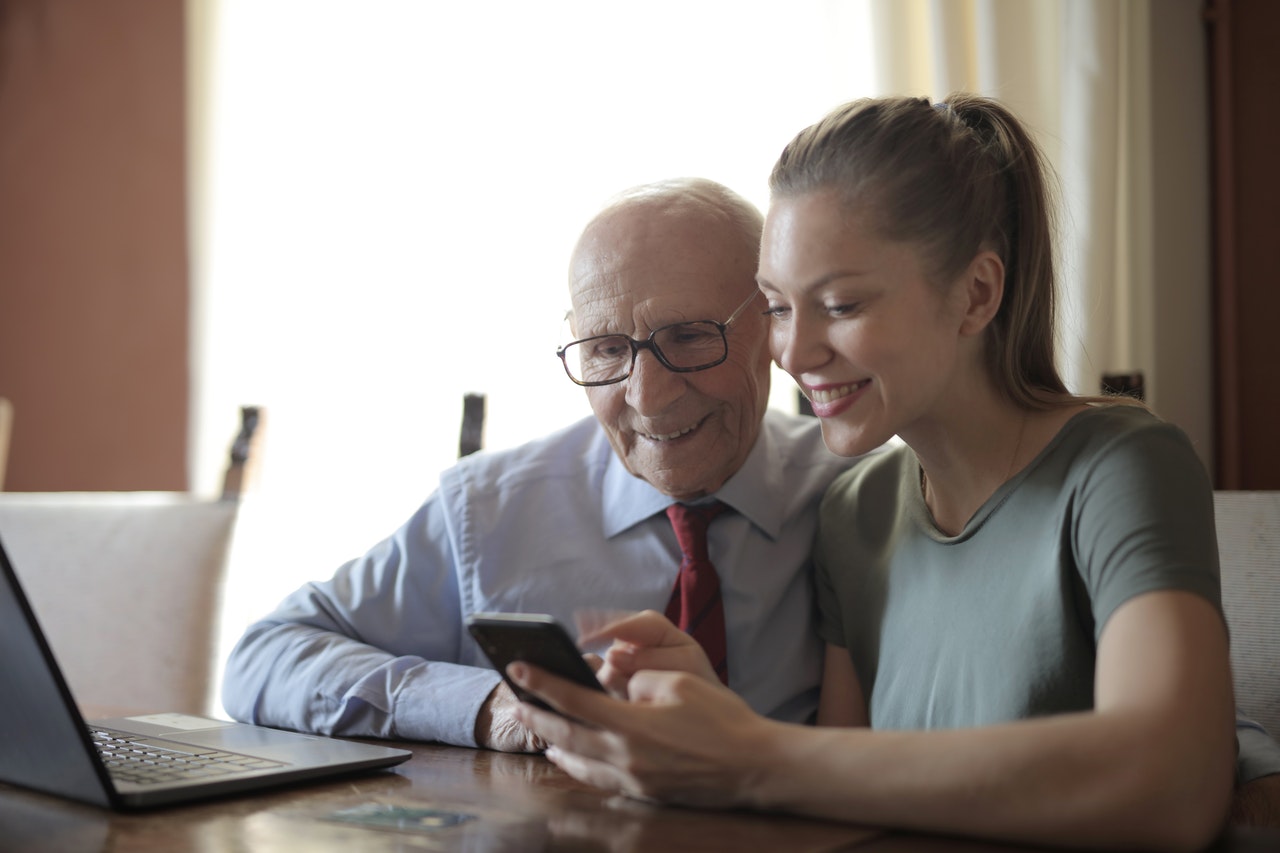 daughter and father looking at the smart phone in a room