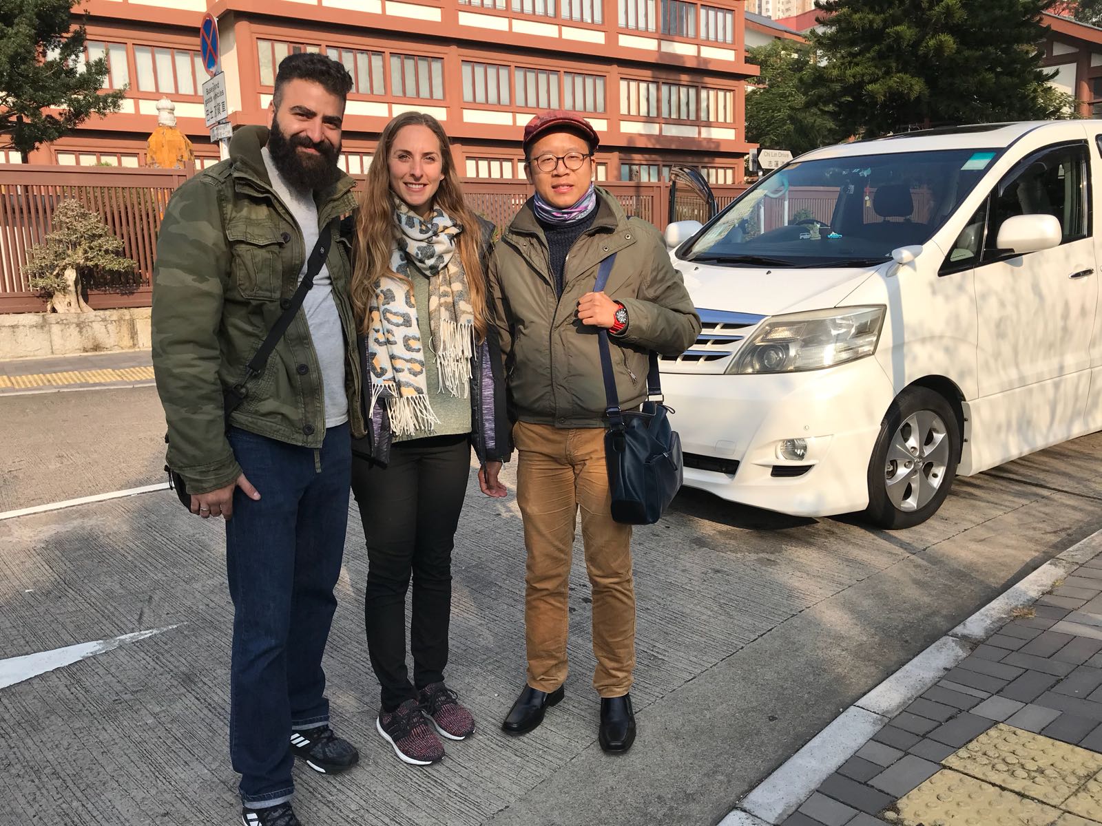 Frank the tour guide takes photo with a young couple client near the private car.