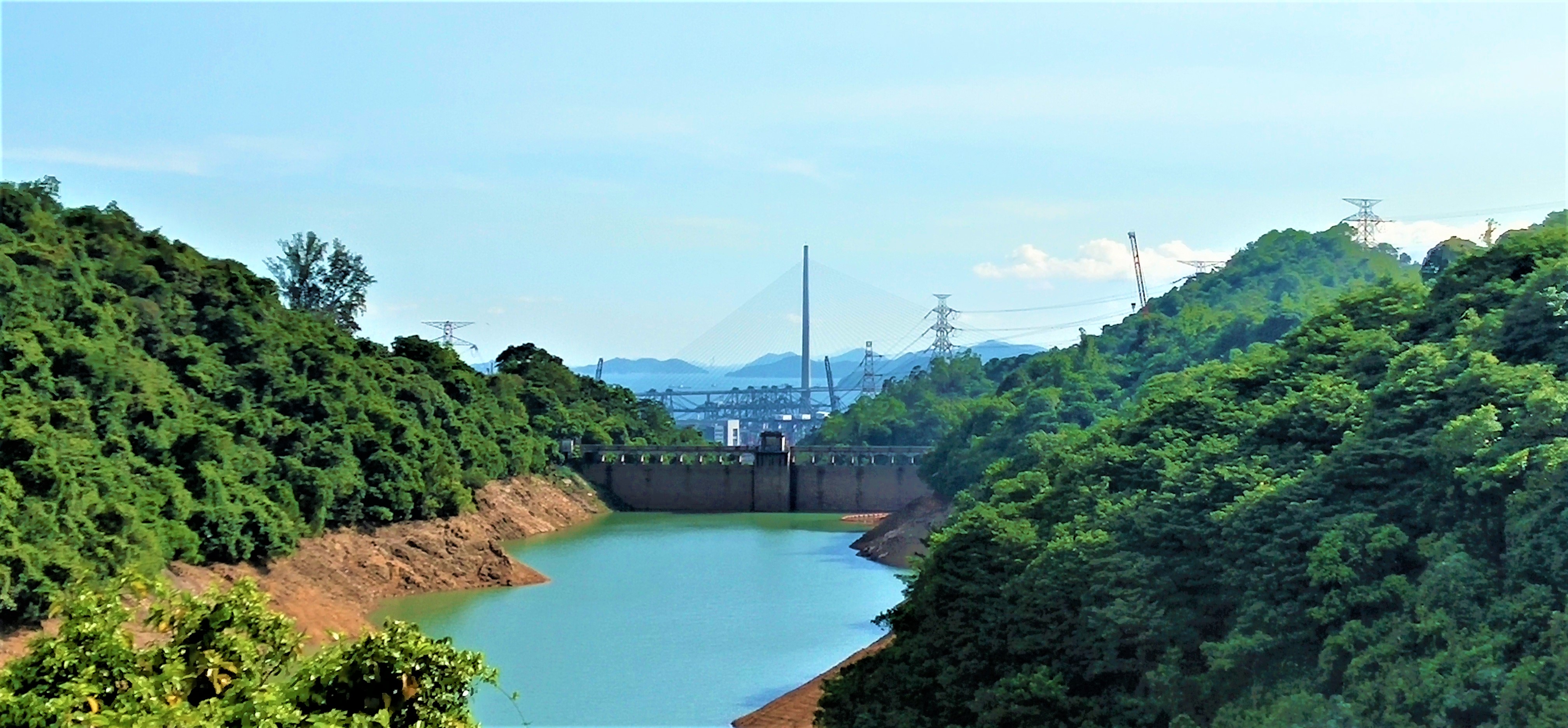 See the long Stonecutter Bridge and busy container terminal from the dam of Kowloon Reservoir