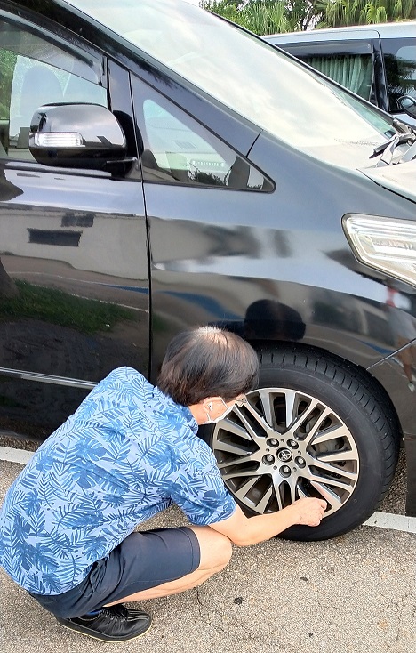 Driver Sam is checking tire pressure.