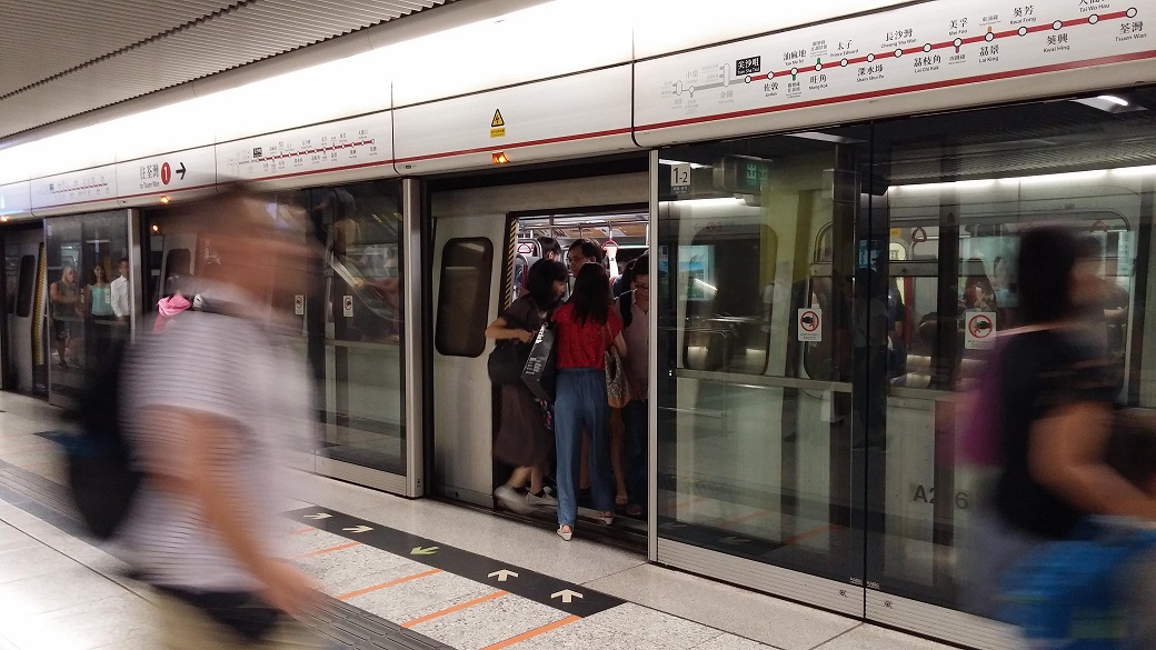 Passengers rush to the crowded train cars.