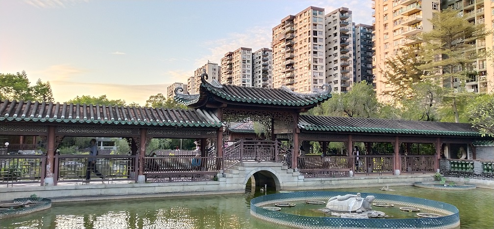 The contrast between the traditional garden and modern high-rise buildings