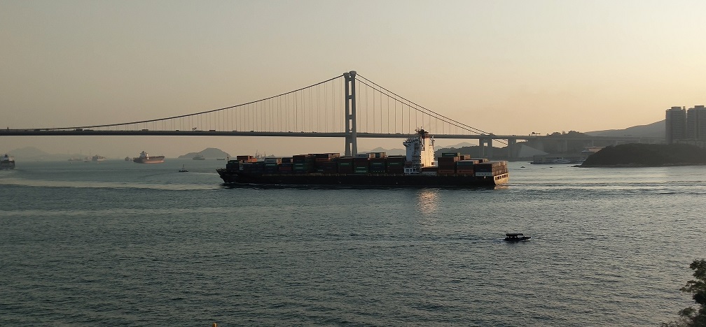 A container ship is going to pass the sea under Tsing Ma Bridge.